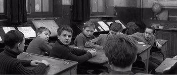 Movie still from “The 400 Blows” (1959), directed by François Truffaut – A group of young men sitting at a table; Medium shot, High angle