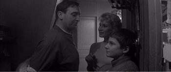 Movie still from “The 400 Blows” (1959), directed by François Truffaut – A black and white photo of a man , woman , and a boy; Medium shot, High angle