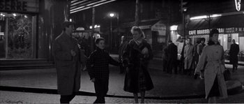 Movie still from “The 400 Blows” (1959), directed by François Truffaut – A woman and a boy walking down a street at night; Wide shot, Over the shoulder angle