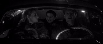 Movie still from “The 400 Blows” (1959), directed by François Truffaut – A man and two women sitting in a car; Medium shot, High angle