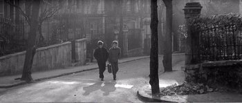 Movie still from “The 400 Blows” (1959), directed by François Truffaut – Two people walking down a street in the snow; Wide shot, High angle