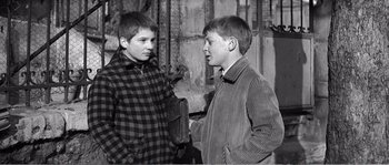 Movie still from “The 400 Blows” (1959), directed by François Truffaut – Two young boys talking to each other in an old photo; Medium shot, Over the shoulder angle
