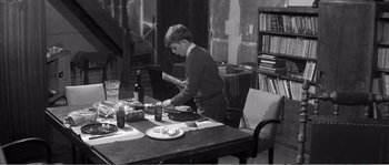 Movie still from “The 400 Blows” (1959), directed by François Truffaut – A young man preparing food on top of a wooden table; Medium shot, High angle