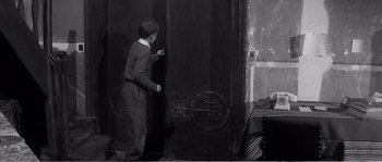 Movie still from “The 400 Blows” (1959), directed by François Truffaut – A young boy standing in front of an open door; Medium shot, High angle
