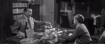 Movie still from “The 400 Blows” (1959), directed by François Truffaut – Two people sitting at a table with a plate of fruit; Medium shot, Over the shoulder angle