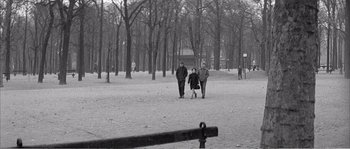 Movie still from “The 400 Blows” (1959), directed by François Truffaut – A group of people walking in a park near a fence; Wide shot, High angle