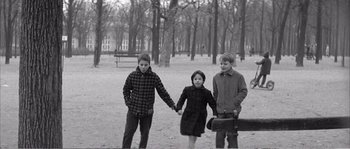 Movie still from “The 400 Blows” (1959), directed by François Truffaut – Three children holding hands while holding hands; Wide shot, High angle