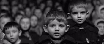 Movie still from “The 400 Blows” (1959), directed by François Truffaut – Black and white photograph of a young boy in front of a crowd; Close Up shot, Low angle