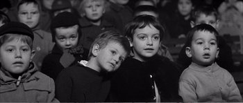 Movie still from “The 400 Blows” (1959), directed by François Truffaut – Two young children standing next to each other in front of a crowd; Close Up shot, High angle