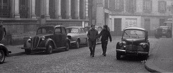 Movie still from “The 400 Blows” (1959), directed by François Truffaut – A couple of people walking down a street; Wide shot, High angle
