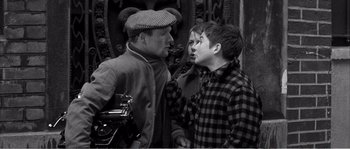 Movie still from “The 400 Blows” (1959), directed by François Truffaut – Two men and a boy talking to each other; Medium shot, Over the shoulder angle