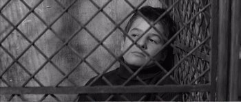 Movie still from “The 400 Blows” (1959), directed by François Truffaut – A young boy sitting behind a chain link fence; Close Up shot, Low angle
