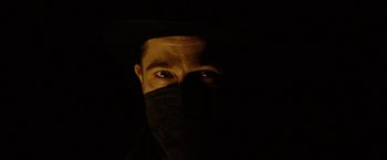 Movie still from “The Assassination of Jesse James by the Coward Robert Ford” (2007), directed by Andrew Dominik – A man wearing a black mask and a black hat; Close Up shot, Low angle