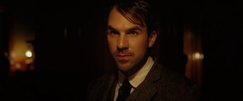 Movie still from “The Assassination of Jesse James by the Coward Robert Ford” (2007), directed by Andrew Dominik – A person wearing a suit and tie; Close Up shot, Over the shoulder angle