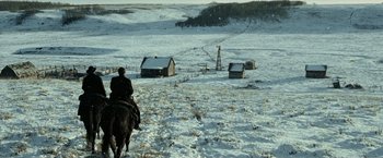 Movie still from “The Assassination of Jesse James by the Coward Robert Ford” (2007), directed by Andrew Dominik – A man riding a horse through a snowy field; Extreme Wide shot, High angle