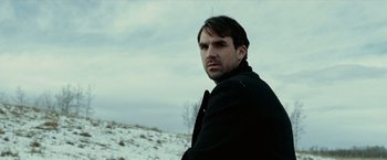 Movie still from “The Assassination of Jesse James by the Coward Robert Ford” (2007), directed by Andrew Dominik – A man standing in the middle of a snowy field; Close Up shot, Low angle