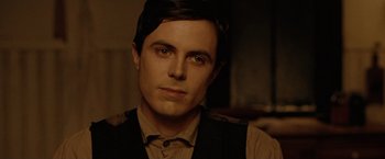 Movie still from “The Assassination of Jesse James by the Coward Robert Ford” (2007), directed by Andrew Dominik – A person wearing a vest looking at the camera; Close Up shot, Over the shoulder angle