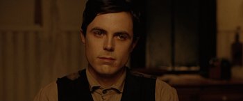Movie still from “The Assassination of Jesse James by the Coward Robert Ford” (2007), directed by Andrew Dominik – A person wearing a suit and tie; Close Up shot, Over the shoulder angle
