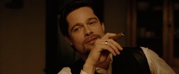 Movie still from “The Assassination of Jesse James by the Coward Robert Ford” (2007), directed by Andrew Dominik – A person holding a cigar; Close Up shot, Over the shoulder angle
