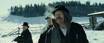 Movie still from “The Assassination of Jesse James by the Coward Robert Ford” (2007), directed by Andrew Dominik – A man with a beard and a hat and a scarf around his neck; Medium shot, Low angle