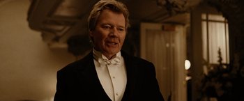 Movie still from “The Assassination of Jesse James by the Coward Robert Ford” (2007), directed by Andrew Dominik – An older man in a tuxedo is looking at the camera; Close Up shot, Over the shoulder angle