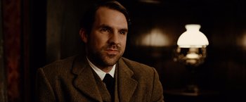 Movie still from “The Assassination of Jesse James by the Coward Robert Ford” (2007), directed by Andrew Dominik – A person wearing a suit and tie; Close Up shot, Over the shoulder angle