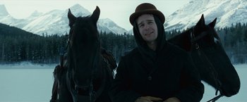 Movie still from “The Assassination of Jesse James by the Coward Robert Ford” (2007), directed by Andrew Dominik – A man wearing a hat standing next to a horse in the snow; Close Up shot, Low angle