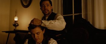 Movie still from “The Assassination of Jesse James by the Coward Robert Ford” (2007), directed by Andrew Dominik – A man sitting next to another man in a chair; Close Up shot, Over the shoulder angle