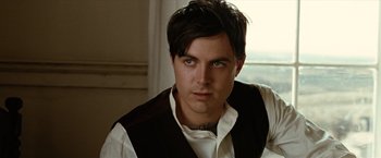 Movie still from “The Assassination of Jesse James by the Coward Robert Ford” (2007), directed by Andrew Dominik – A person wearing a shirt and vest; Close Up shot, Over the shoulder angle