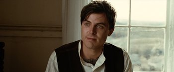 Movie still from “The Assassination of Jesse James by the Coward Robert Ford” (2007), directed by Andrew Dominik – A person wearing a shirt and a vest; Close Up shot, Over the shoulder angle