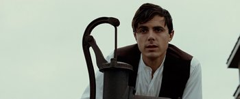 Movie still from “The Assassination of Jesse James by the Coward Robert Ford” (2007), directed by Andrew Dominik – A man in a vest and tie leaning on a chair; Close Up shot, Low angle