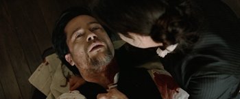 Movie still from “The Assassination of Jesse James by the Coward Robert Ford” (2007), directed by Andrew Dominik – A man laying on the ground with blood on his face; Close Up shot, Overhead angle