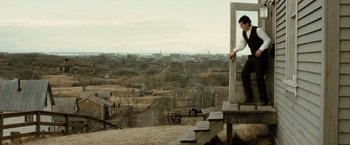 Movie still from “The Assassination of Jesse James by the Coward Robert Ford” (2007), directed by Andrew Dominik – A man standing on top of a wooden platform; Wide shot, High angle