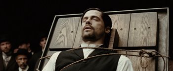 Movie still from “The Assassination of Jesse James by the Coward Robert Ford” (2007), directed by Andrew Dominik – A man is tied to a wooden chair; Close Up shot, High angle