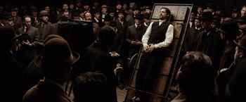 Movie still from “The Assassination of Jesse James by the Coward Robert Ford” (2007), directed by Andrew Dominik – A group of people in a room with a painting; Wide shot, High angle