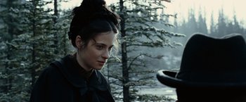Movie still from “The Assassination of Jesse James by the Coward Robert Ford” (2007), directed by Andrew Dominik – A young woman in a black dress is looking at the camera; Close Up shot, Over the shoulder angle