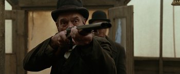 Movie still from “The Assassination of Jesse James by the Coward Robert Ford” (2007), directed by Andrew Dominik – A man in a hat and a hat is holding a gun; Close Up shot, Low angle