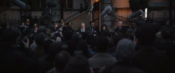 Movie still from “The Batman” (2022), directed by Matt Reeves – A group of men and women standing in front of a crowd; Wide shot, Over the shoulder angle