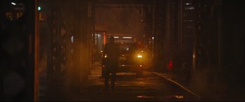 Movie still from “The Batman” (2022), directed by Matt Reeves – A person standing in front of a car at night; Extreme Wide shot, Over the shoulder angle