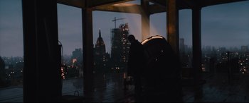 Movie still from “The Batman” (2022), directed by Matt Reeves – A man standing under an umbrella in the rain; Extreme Wide shot, Low angle
