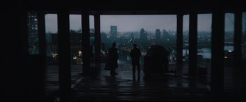 Movie still from “The Batman” (2022), directed by Matt Reeves – Two people are standing in the rain looking out at the city; Extreme Wide shot, Over the shoulder angle