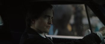 Movie still from “The Batman” (2022), directed by Matt Reeves – A person in a car looking out of the window; Close Up shot, Over the shoulder angle
