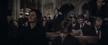 Movie still from “The Batman” (2022), directed by Matt Reeves – A group of men in suits and ties sitting in a church; Wide shot, Over the shoulder angle