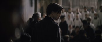 Movie still from “The Batman” (2022), directed by Matt Reeves – A person wearing a suit and tie; Close Up shot, Over the shoulder angle