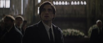 Movie still from “The Batman” (2022), directed by Matt Reeves – A person wearing a suit and tie; Close Up shot, Low angle