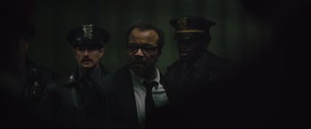 Movie still from “The Batman” (2022), directed by Matt Reeves – A group of men standing next to each other in a dark room; Close Up shot, Over the shoulder angle