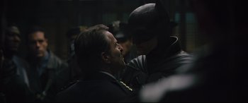 Movie still from “The Batman” (2022), directed by Matt Reeves – A man and a man in a batman costume; Medium shot, Over the shoulder angle