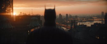 Movie still from “The Batman” (2022), directed by Matt Reeves – A man in a batman costume looking out over a city at sunset; Extreme Wide shot, Low angle
