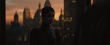 Movie still from “The Batman” (2022), directed by Matt Reeves – A woman standing in front of a city at sunset; Medium shot, Over the shoulder angle