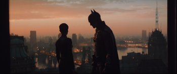 Movie still from “The Batman” (2022), directed by Matt Reeves – A man and a woman standing next to each other on top of a building; Medium shot, Low angle